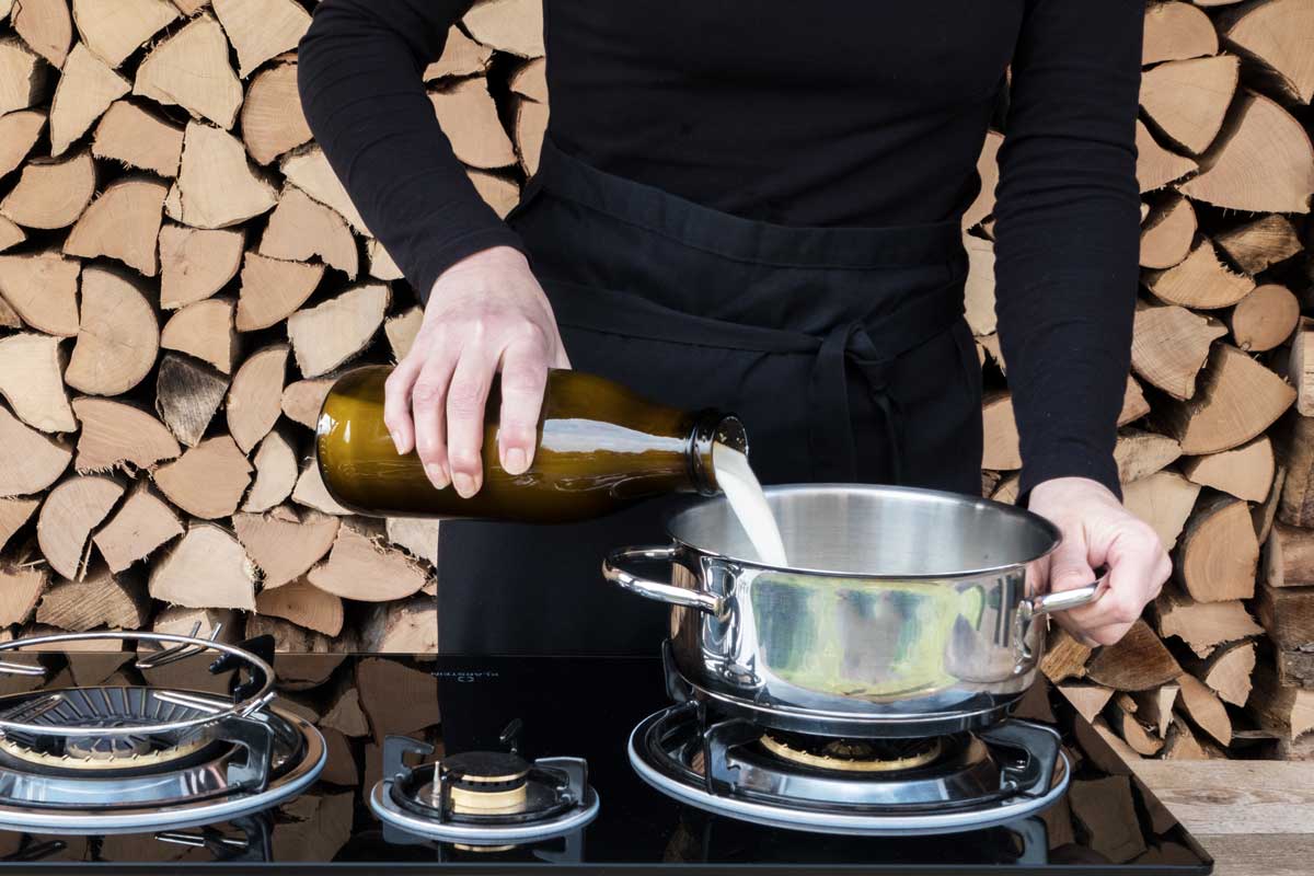 Milch wird in einem Topf auf dem Herd erhitzt – erster Schritt beim Joghurt selbst machen